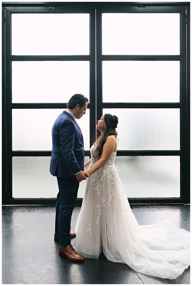 Couple holding hands in wedding attire.