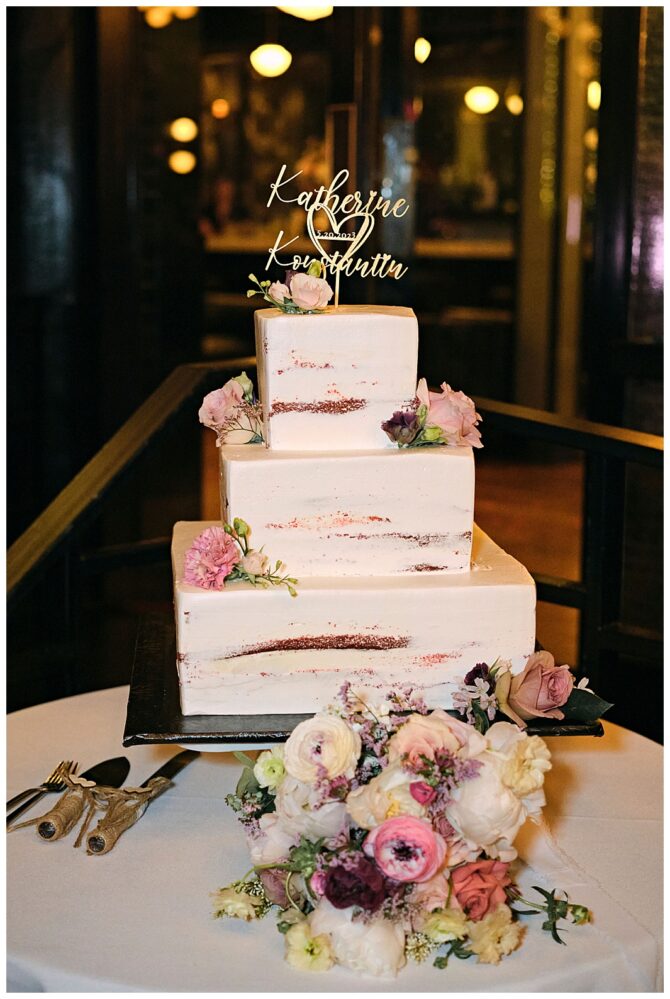 Three-tier wedding cake with floral decorations.