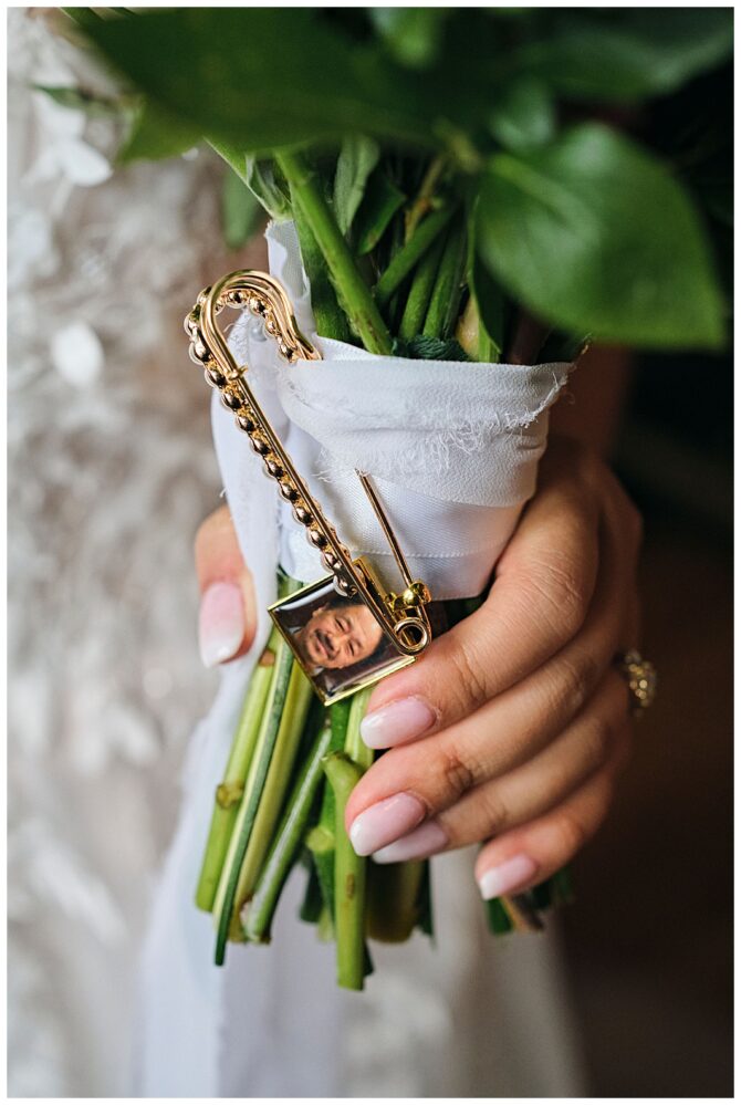 Bride holding bouquet with photo charm