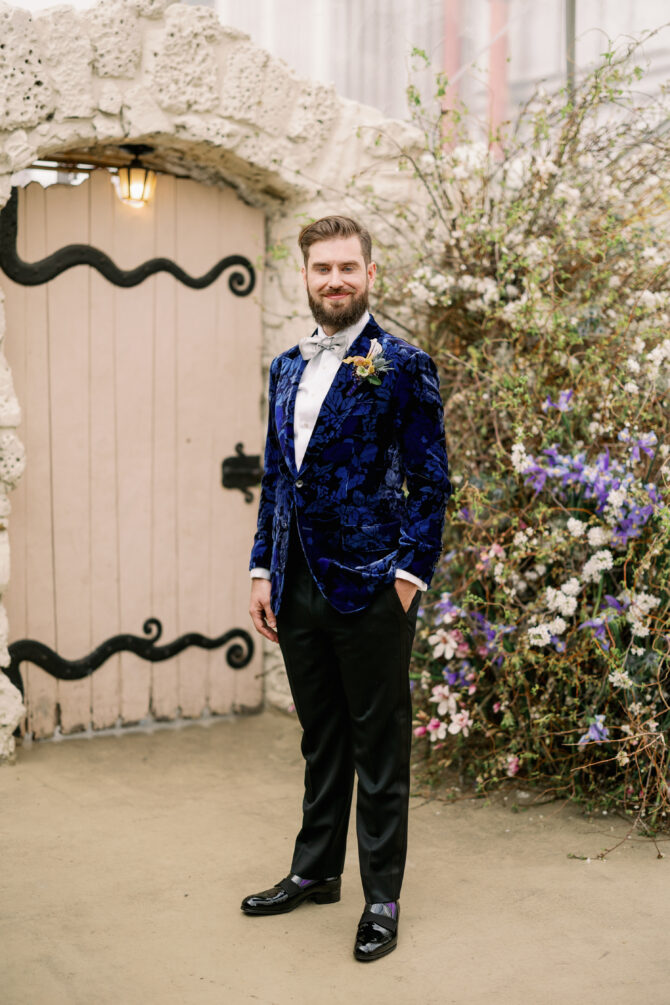Man in floral suit by garden gate