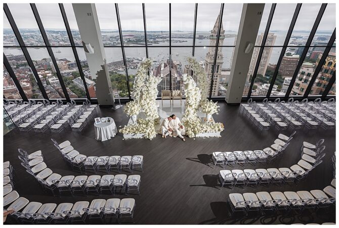 Elegant indoor wedding ceremony with city view.