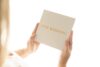 Person holding 'Our Wedding' invitation card