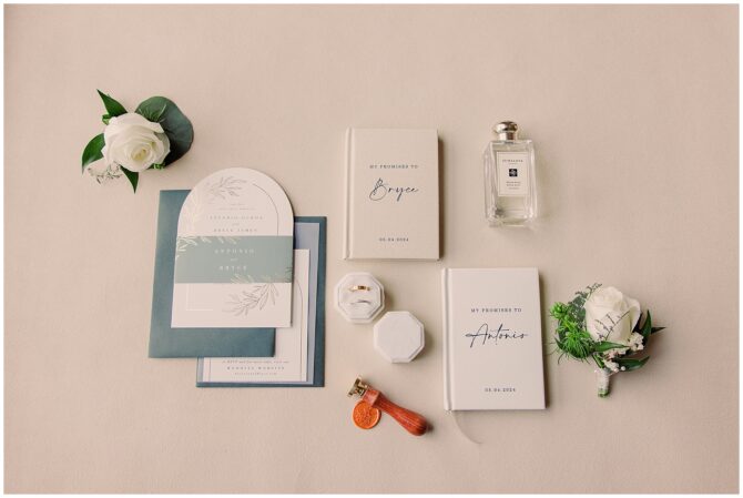 Wedding invitation and accessories layout on table.