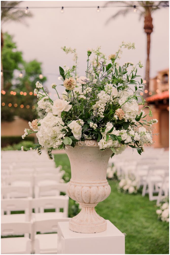 Elegant white floral arrangement at outdoor wedding ceremony