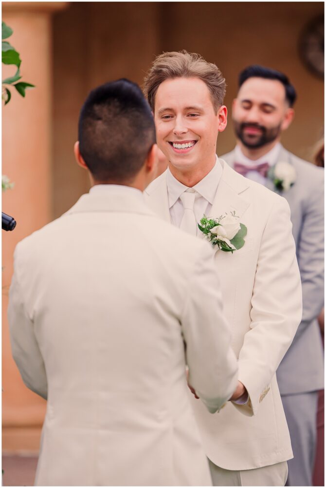 Two grooms exchanging vows at wedding ceremony.