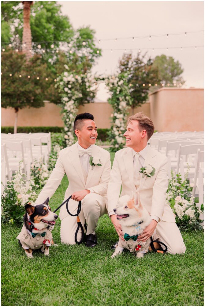 Grooms with dogs at outdoor wedding ceremony.
