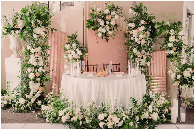 Elegant wedding table with floral arch decor.