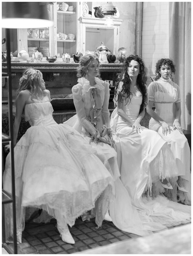 Four women in vintage dresses sitting together.