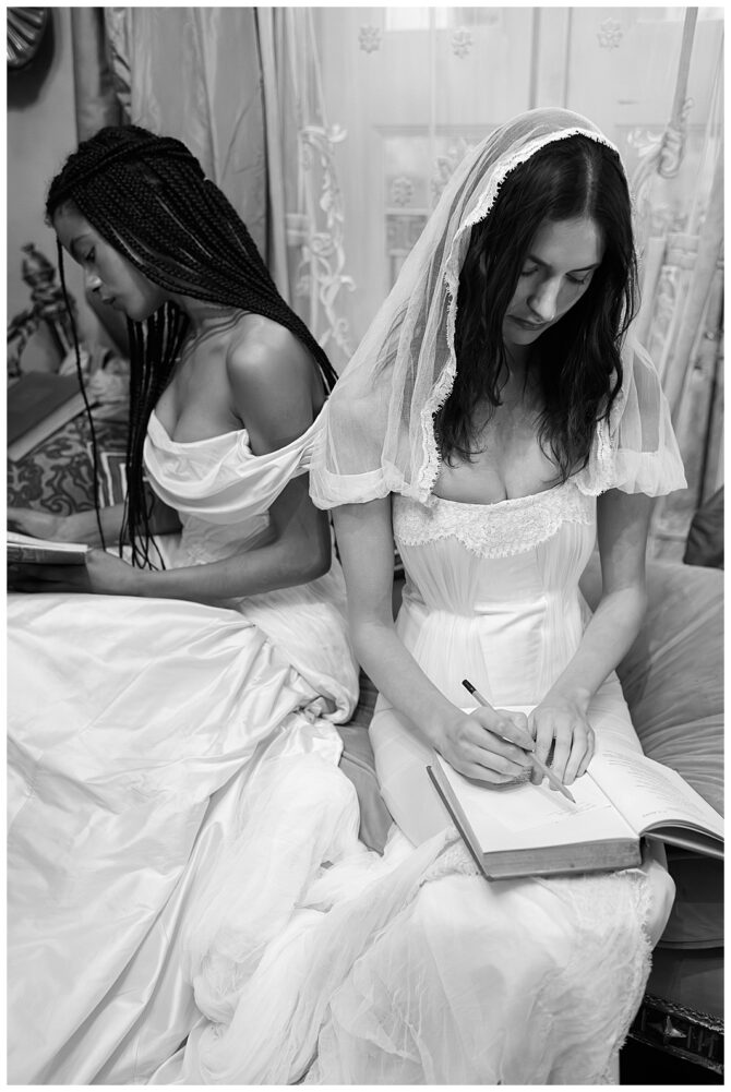 Women in gowns writing in journals, black and white