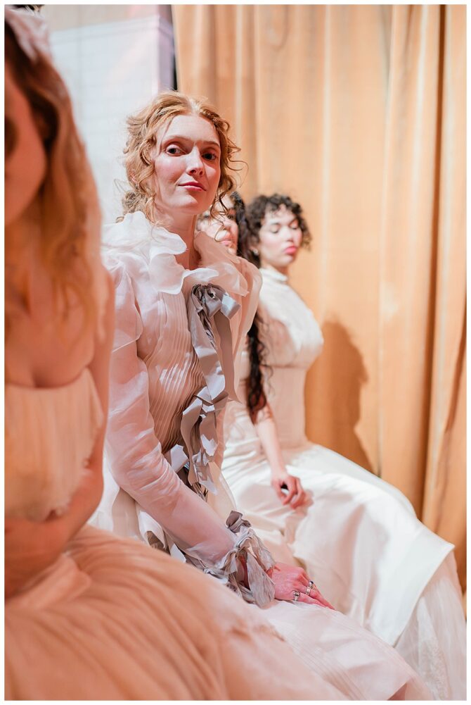Women in elegant cream dresses sitting indoors