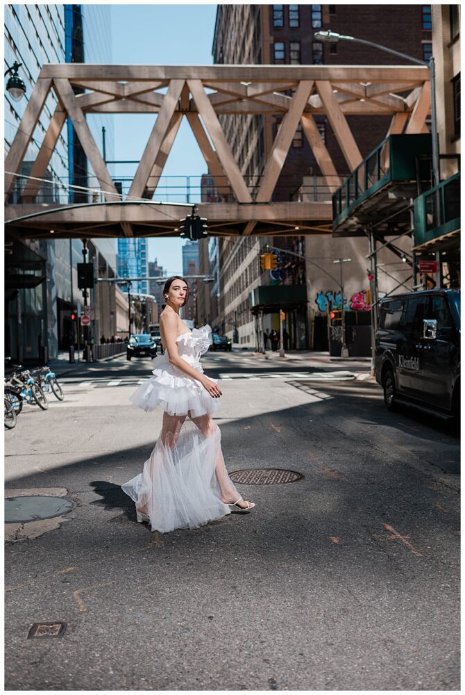 Fashionable woman in white dress walking city street