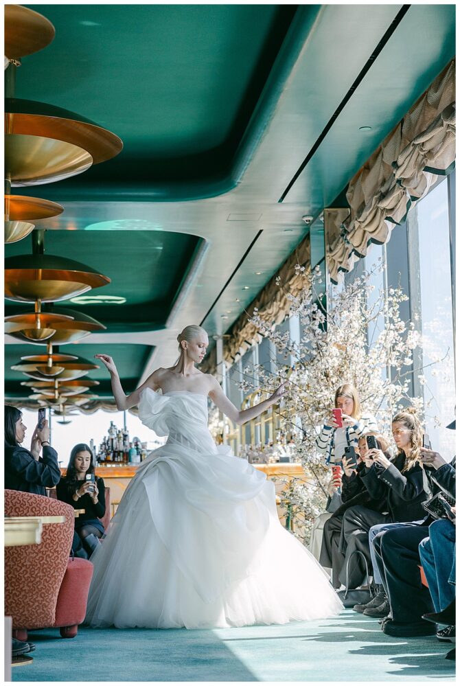 Bride modeling elegant wedding dress in stylish venue.