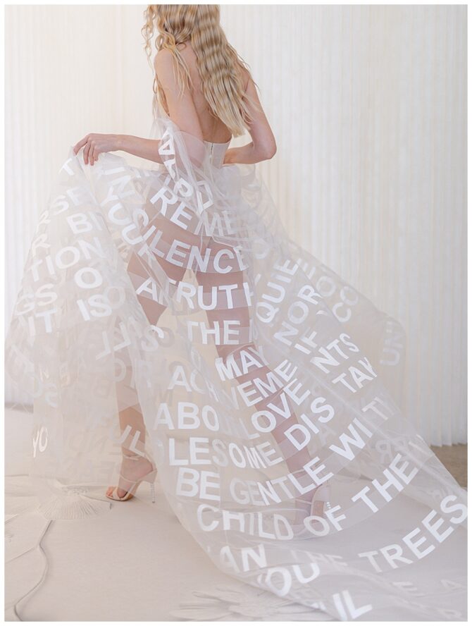 Model in sheer dress with white text design