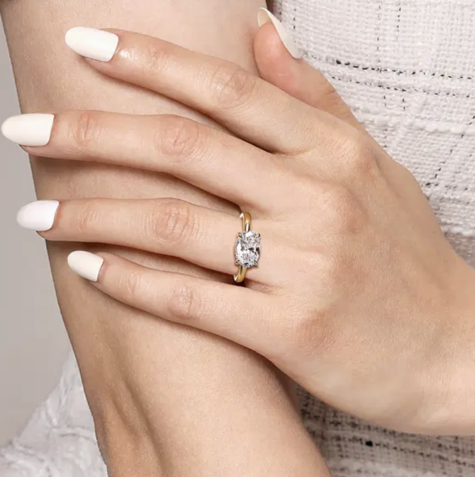 Hand wearing a diamond engagement ring