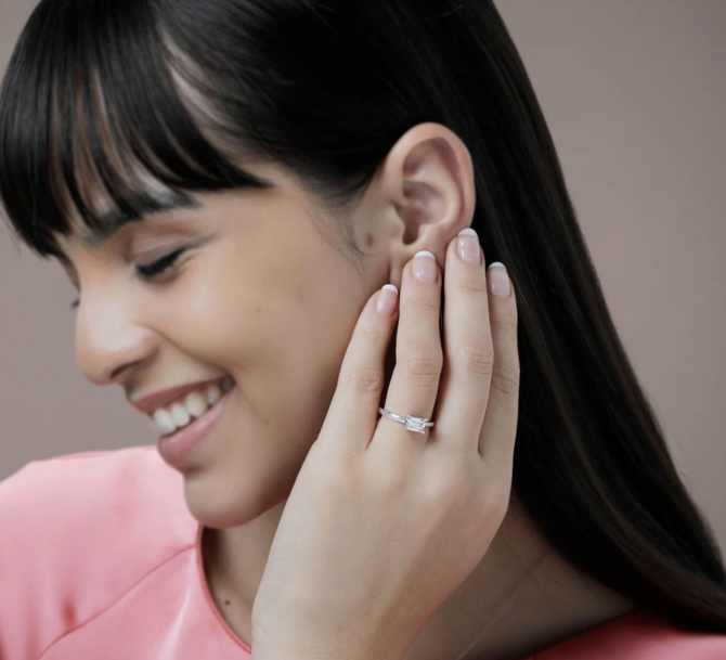 Smiling woman wearing an elegant diamond ring.